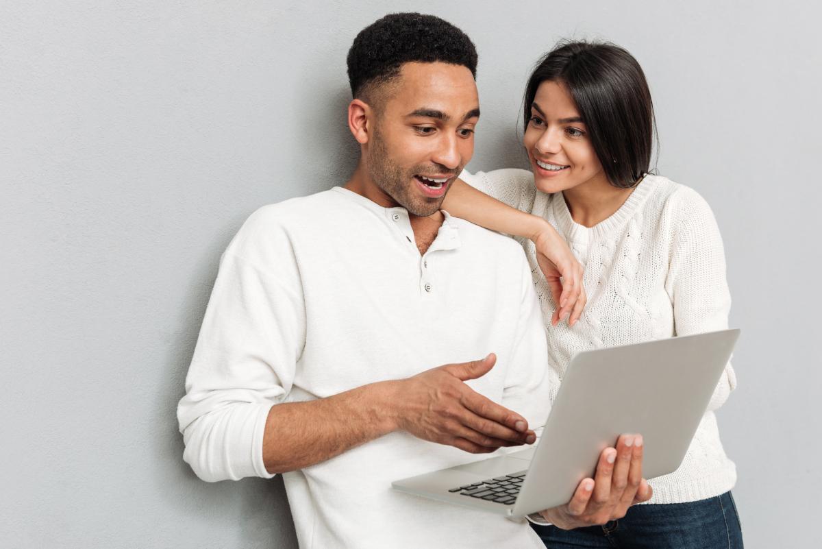 Visuel de personnes consultant un ordinateur en souriant