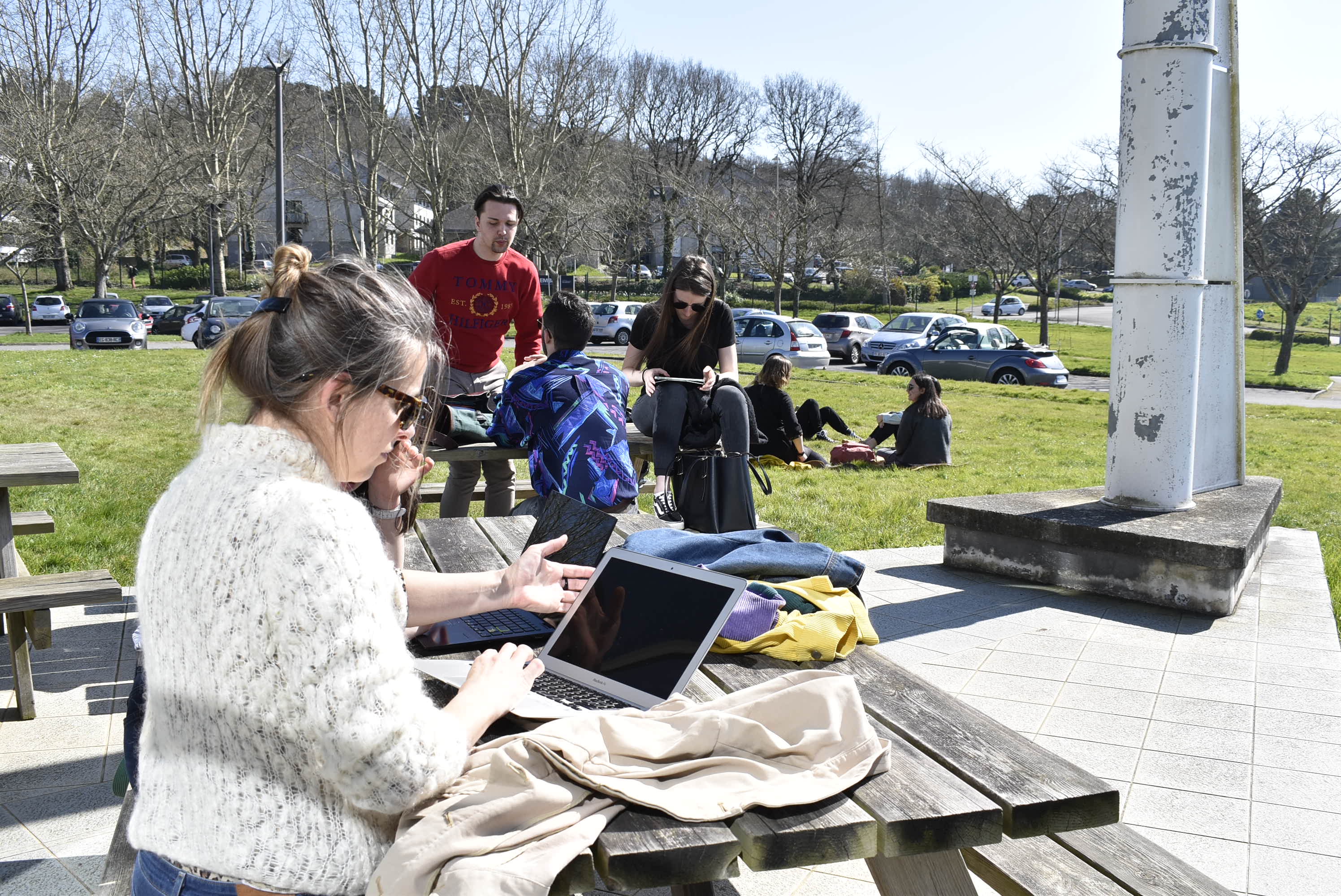 Une étudiante travaille sur une des tables extérieures du campus
