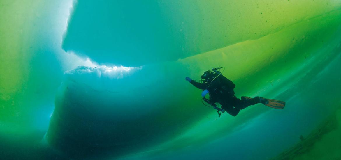 Plongeur qui nage dans mer bleue-verte