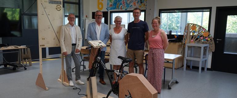 lÉquipe projet pose avec le président devant le premier vélo-batterie réalisé