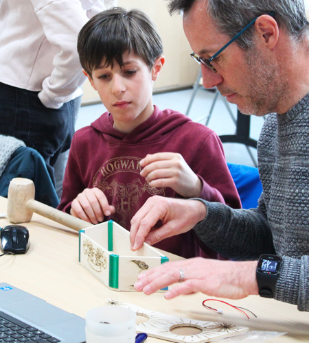 père et son fils construisant une enceinte bluetooth